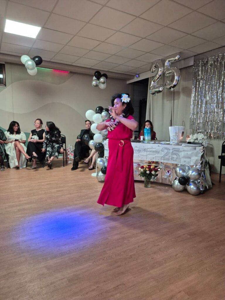 Een gast danst solo op de vloer, met ballonnen en een feesttafel erachter